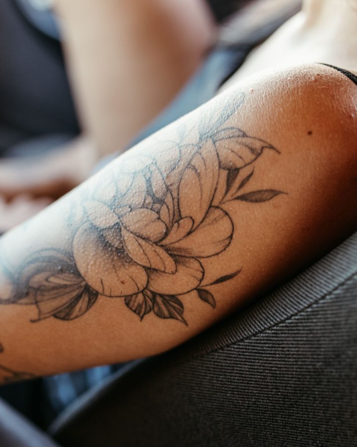 Femme avec tatouage floral détaillé sur le bras