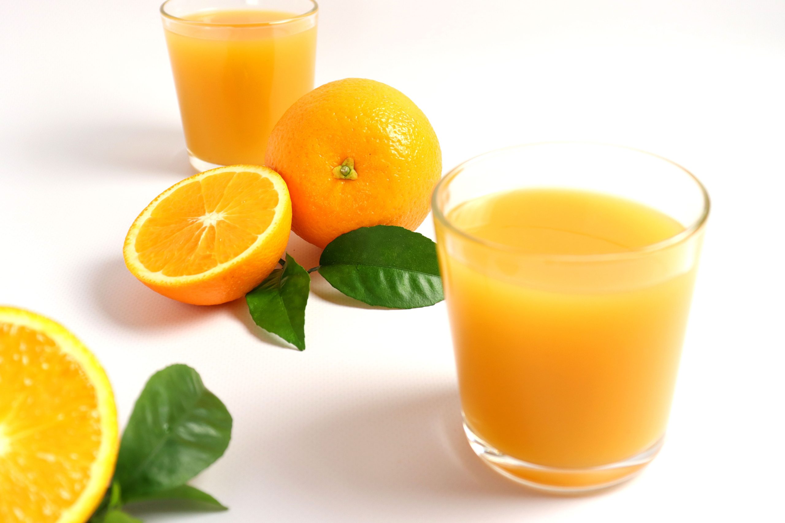Jus d'orange frais avec oranges entières et tranchées