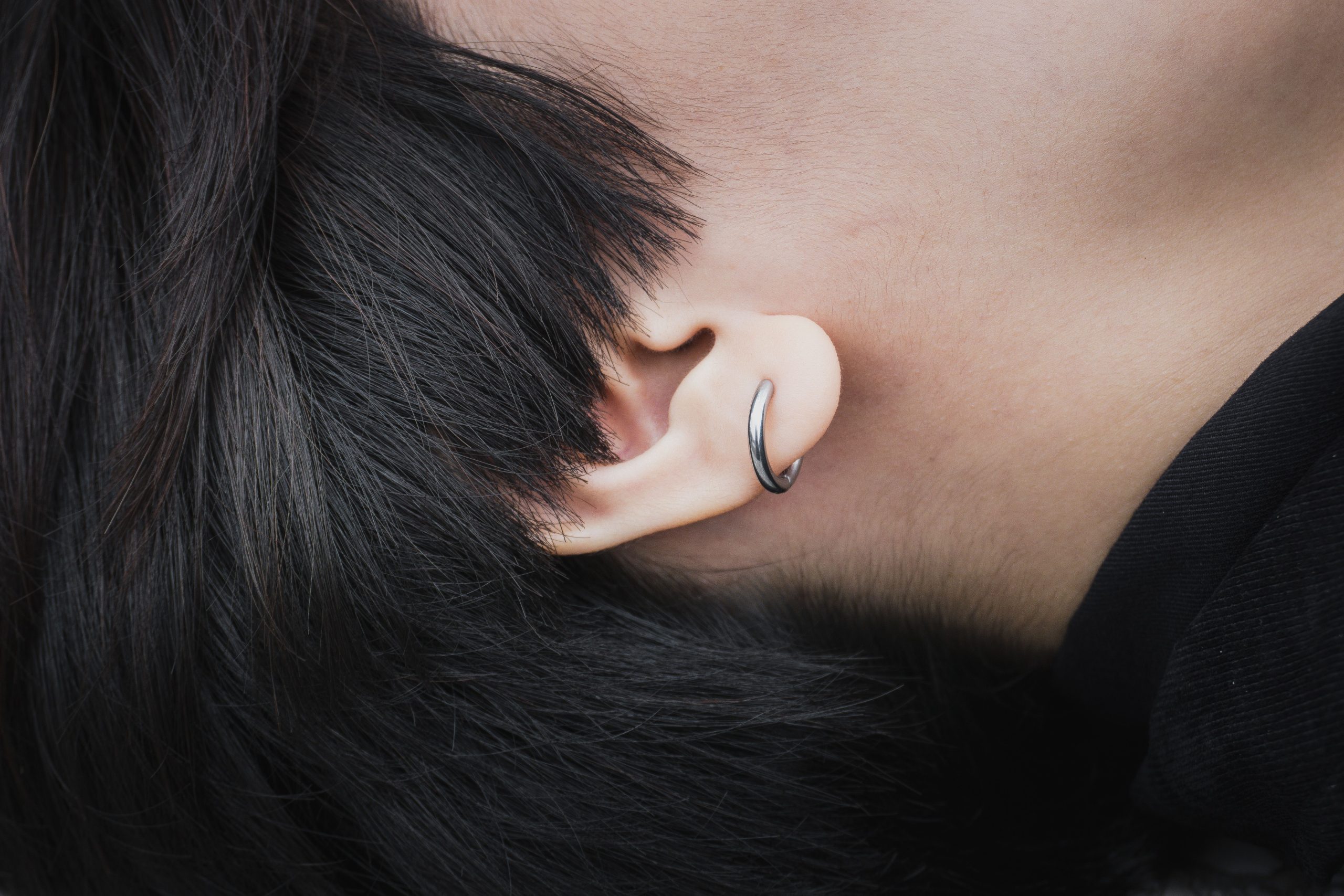 Gros plan oreille avec boucle d'oreille argent