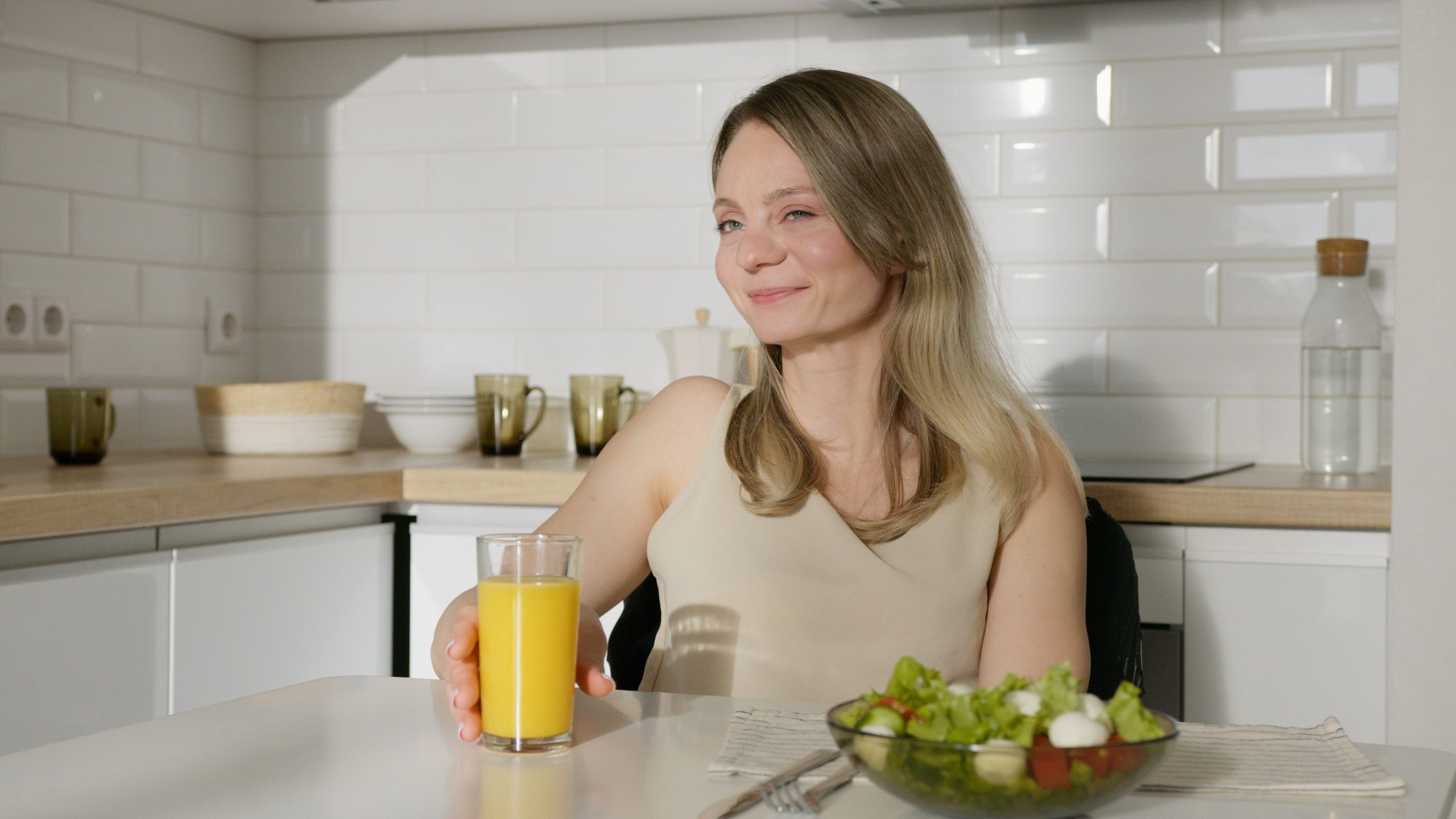 Femme mangeant une salade équilibrée en cuisine