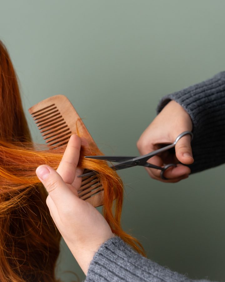 Cheveux rouges coupés aux ciseaux sur fond vert