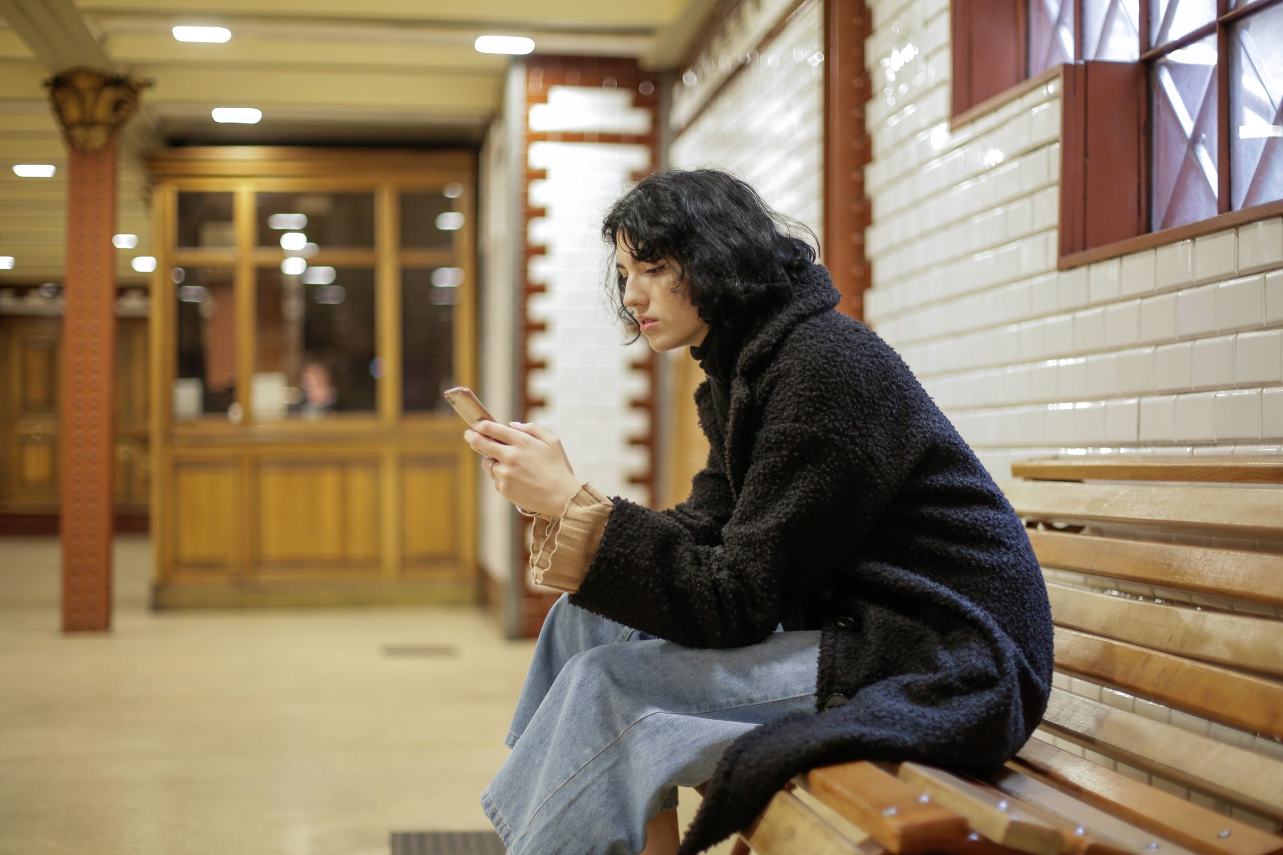 Jeune femme consultando son téléphone sur un banc