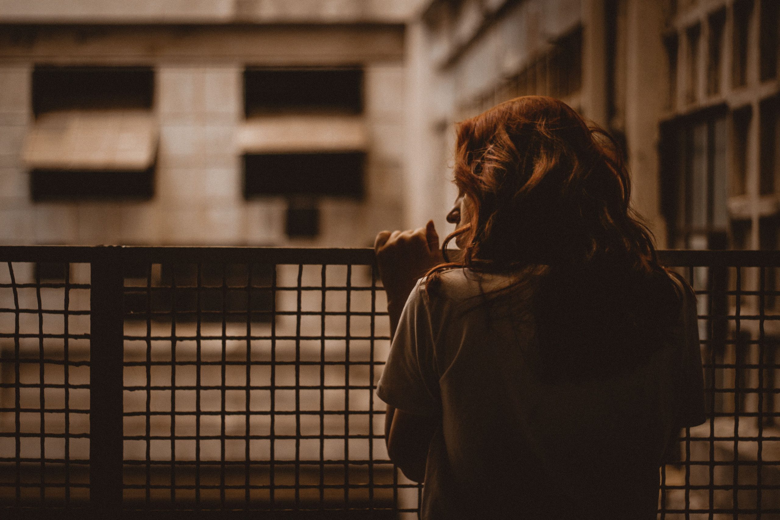 Femme contemplative seule derrière une balustrade