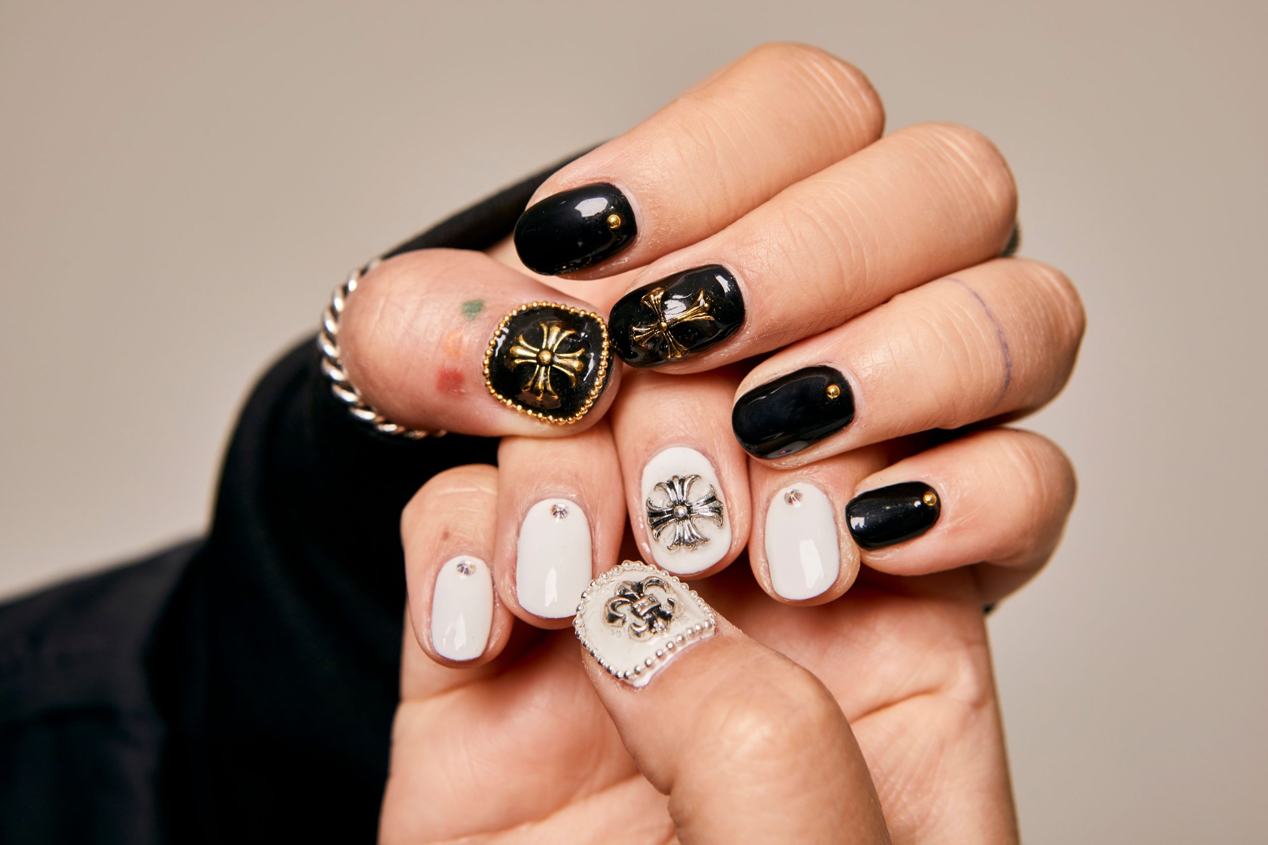 Mains avec nail art noir et blanc orné