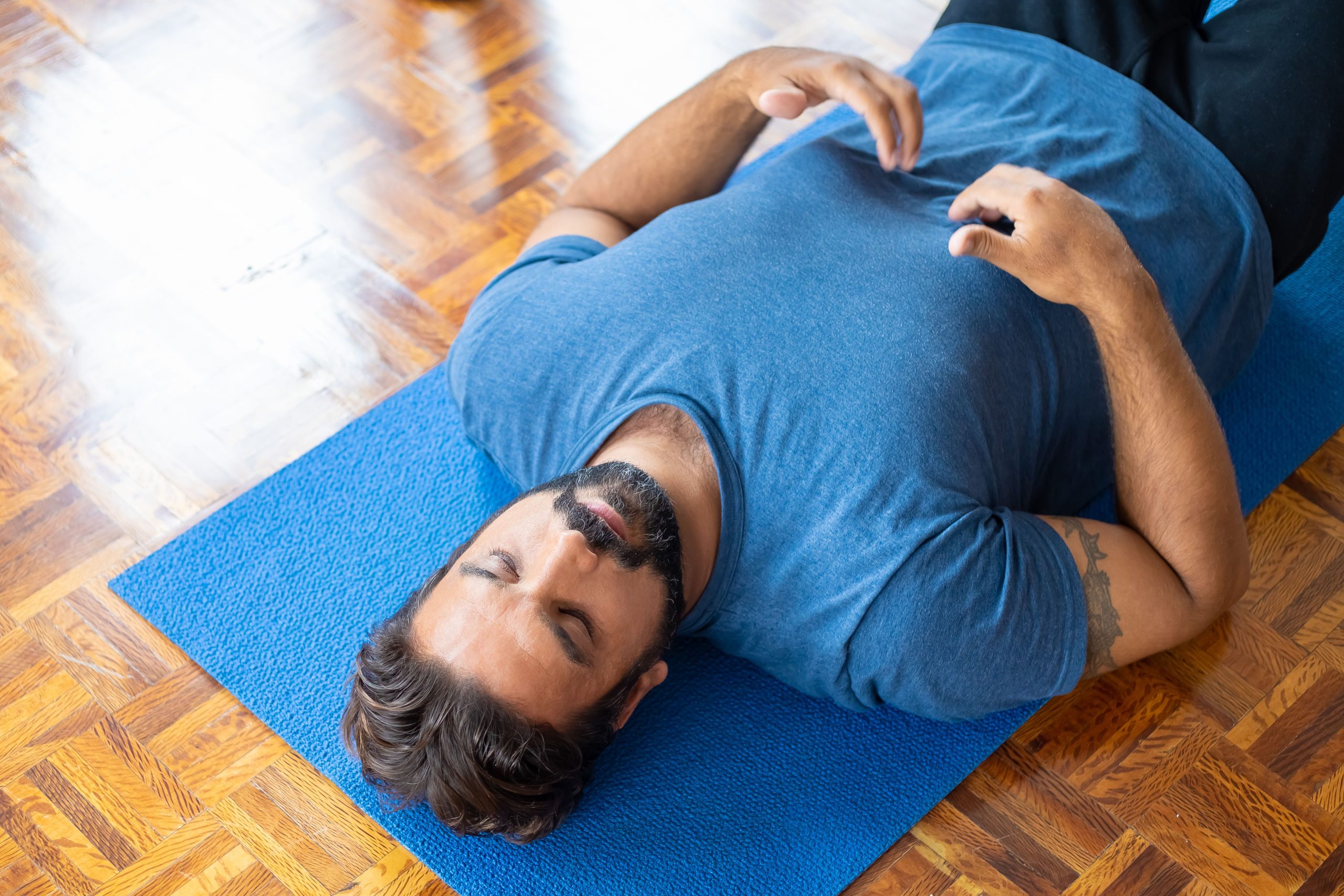 Homme relaxant sur tapis de yoga en pleine conscience