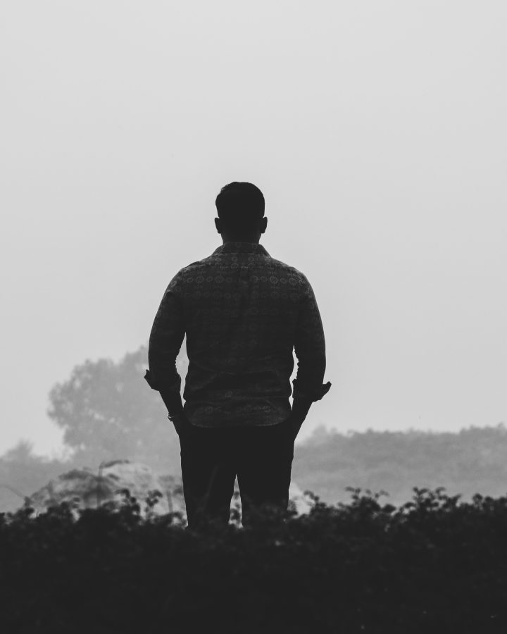 Silhouette d'un homme seul dans un paysage brumeux