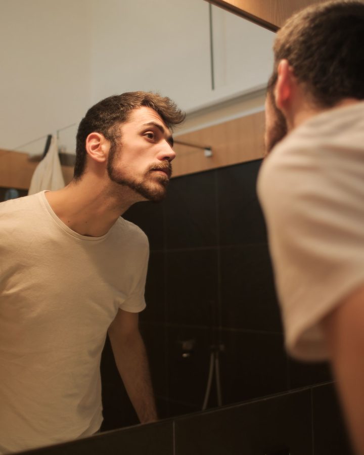Jeune homme vérifiant sa barbe naissante