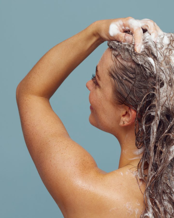 Femme lavant ses cheveux longs avec du shampoing