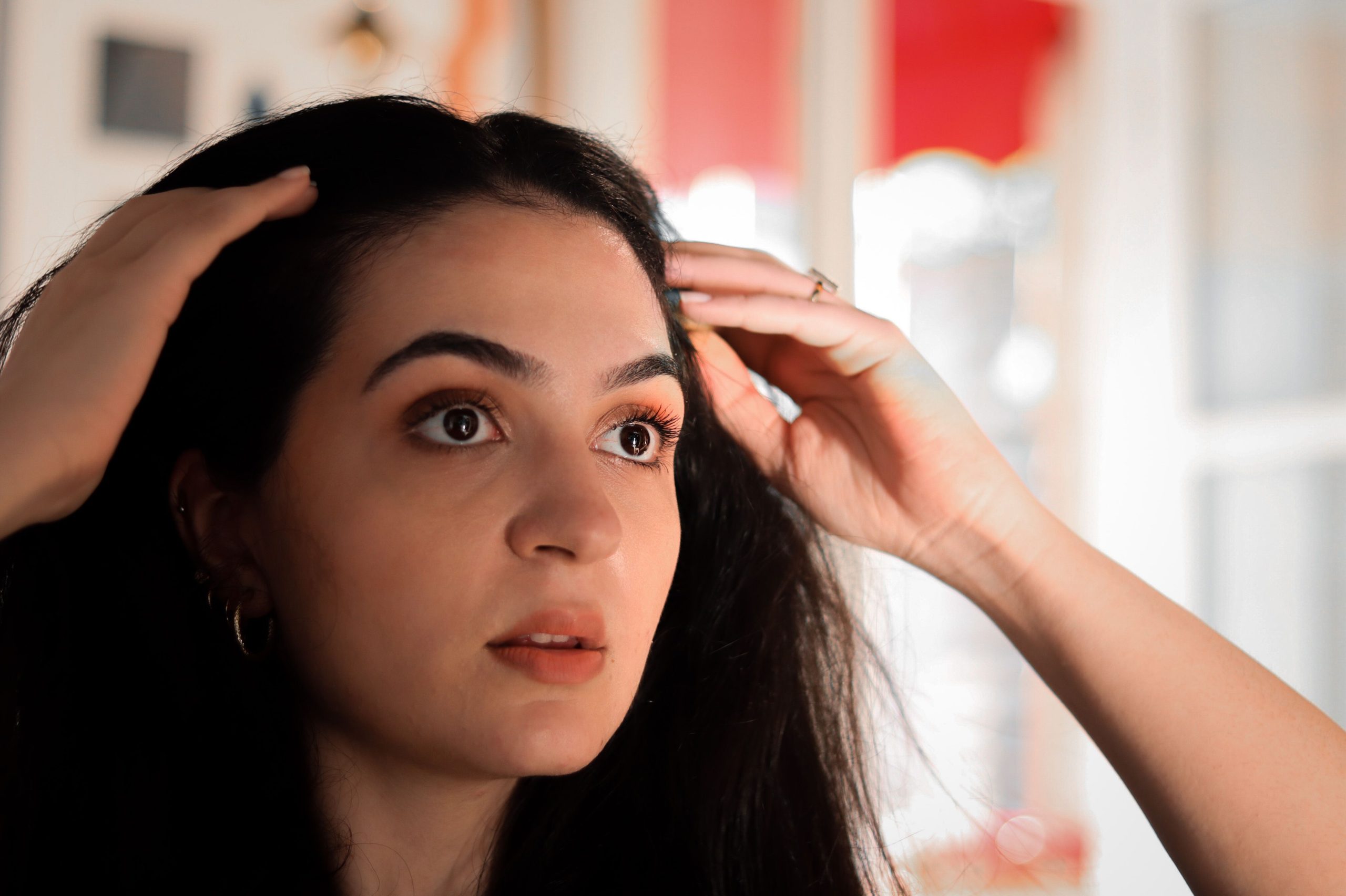 Jeune femme touchant ses cheveux chez elle
