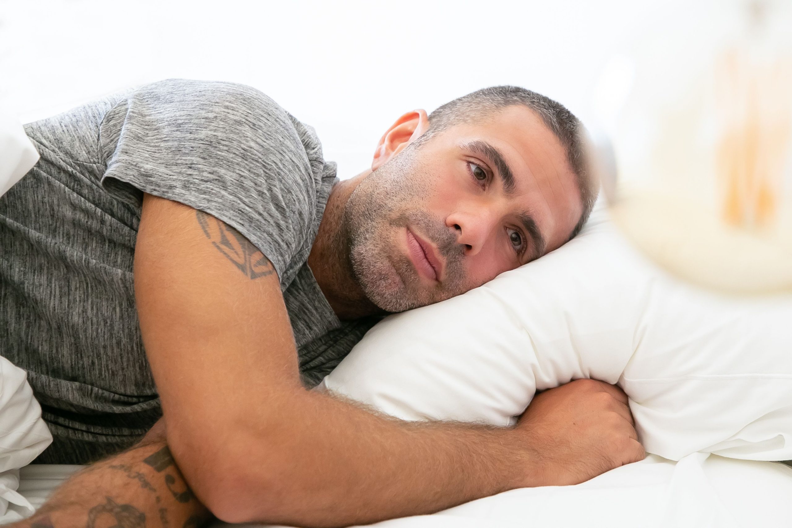 Homme allongé sur un oreiller, pensif